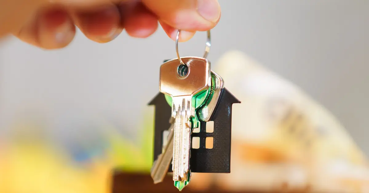 Clés d'un logement tenues au-dessus d'une table